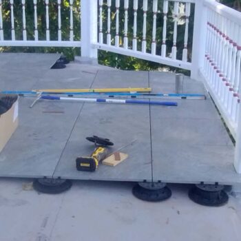Sierra Graphite porcelain pavers over Buzon height-adjustable pedestals. Slope correctors keep the surface level while spacer tabs allow water drainage between the pavers.