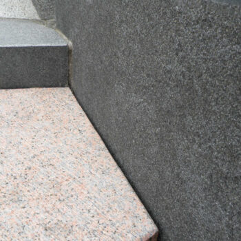 Adze Finished Athens Red Granite Block Meets Lychee Bush-Hammered Bigio Grey Granite