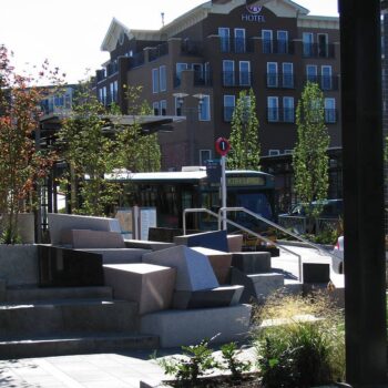 Bus Arriving to Kirkland Transit Hub with Granite Block Public Art in View