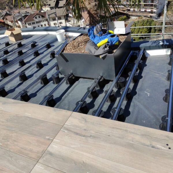 Wood-look porcelain paver planks on E-BRS Easy Rail System with perimeter containment.