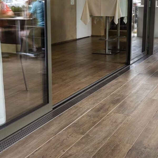 Espiro Indie Brown porcelain planks on E-BRS system at indoor-outdoor dining transition.