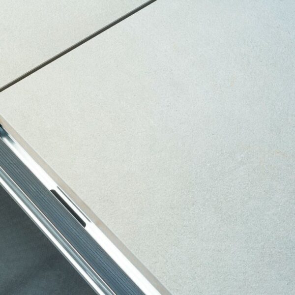 Punched drain hole in Easy Rail joist system between porcelain pavers for complete water drainage.
