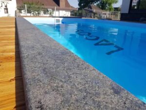 Flamed HDG Black Sea Blue Granite used in a pool surround for slip resistance and refined appearance.