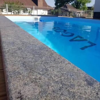 Flamed HDG Black Sea Blue Granite used in a pool surround for slip resistance and refined appearance.