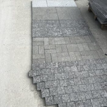 HDG Black Sea Blue Granite samples showing different finishes laid out in the stoneyard for side-by-side comparison.