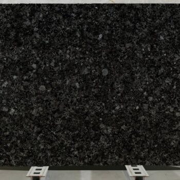 Very large Black Sea Blue Granite slab mounted on rails, ready for architectural cladding installation.