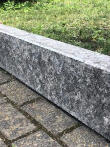 Tall Black Sea Blue Granite curbstone installed alongside brick-shaped granite pavers.