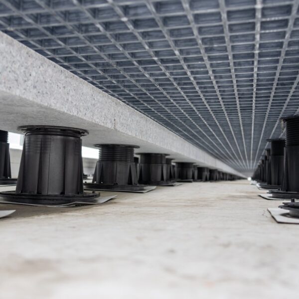 Ground-level view of pedestal system supporting grating panels with ballast above