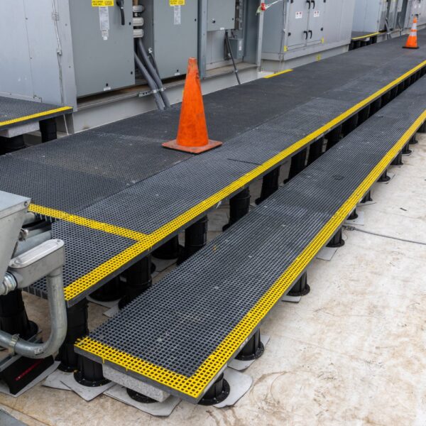 Overview of rooftop access system with grating platforms, equipment, and safety markers