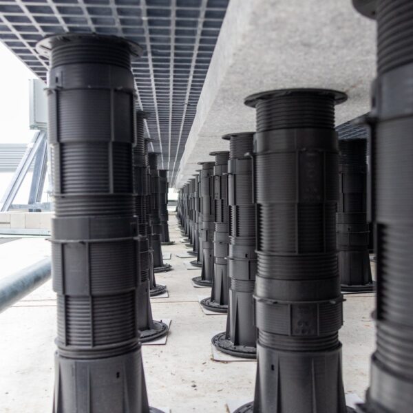 Tall pedestal supports with couplers, ballast, and grating panel assembly at rooftop edge