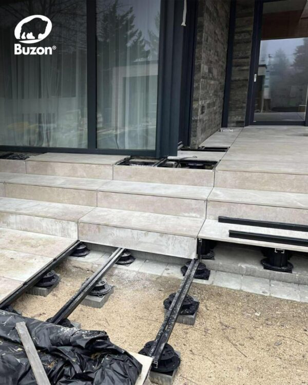 Buzon pedestals and E-BRS rails installed over dirt and concrete substrate during private terrace construction