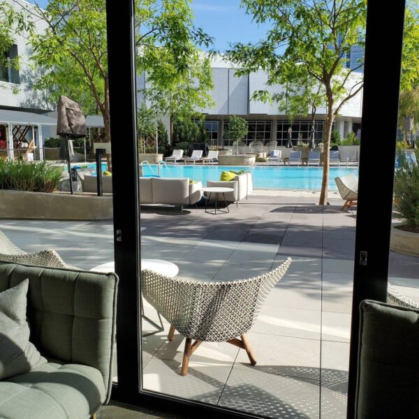 View from interior through sliding doors at Kimpton Sawyer Hotel pool deck constructed over Buzon pedestal system with wood and concrete pavers