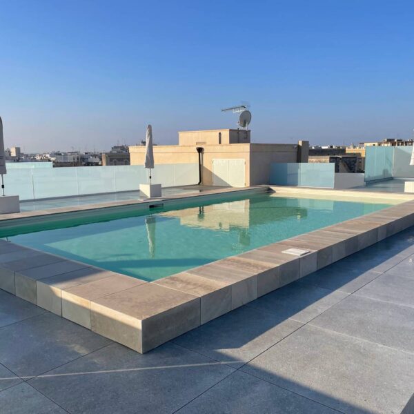 Seamless porcelain pool deck terrace built over pedestal system with clean edge detailing and no visible trim profiles