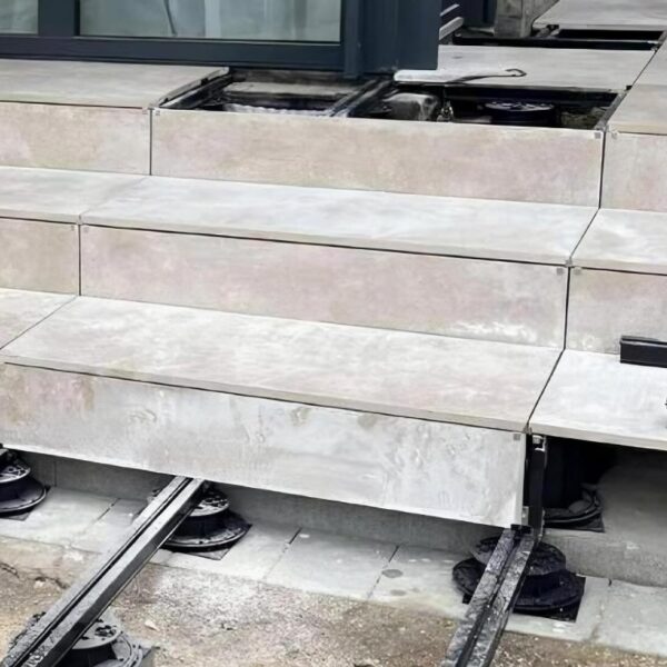Buzon pedestals and E-BRS rails installed over dirt and concrete substrate to create a raised terrace on uneven ground