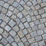 Closeup of cobblestone pavers showing permeable gaps and irregular joint spacing.
