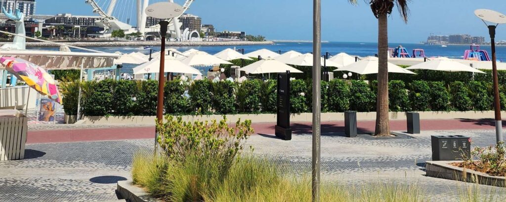 Completed granite promenade at The Beach at Jumeirah Beach Residence in Dubai featuring sweeping wave patterns, natural stone paving, and a vibrant public waterfront space.