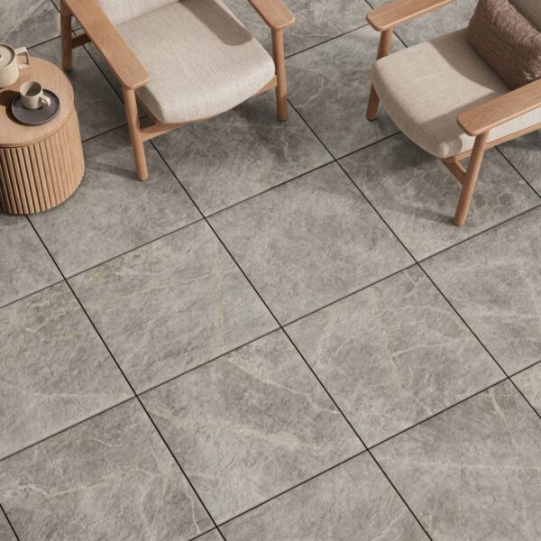 Marmo Gray 60x60cm porcelain pavers surround a modern outdoor seating area with wood chairs, a side table, and coffee service.