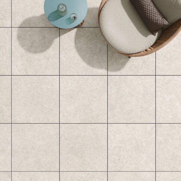 Slate White 24x24-inch porcelain pavers create a modern patio with outdoor seating and a metal table.
