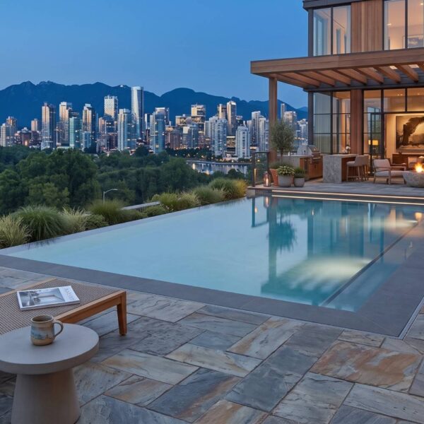 Slatestone porcelain pavers create a pool deck and outdoor living area beside a modern wood and glass home.