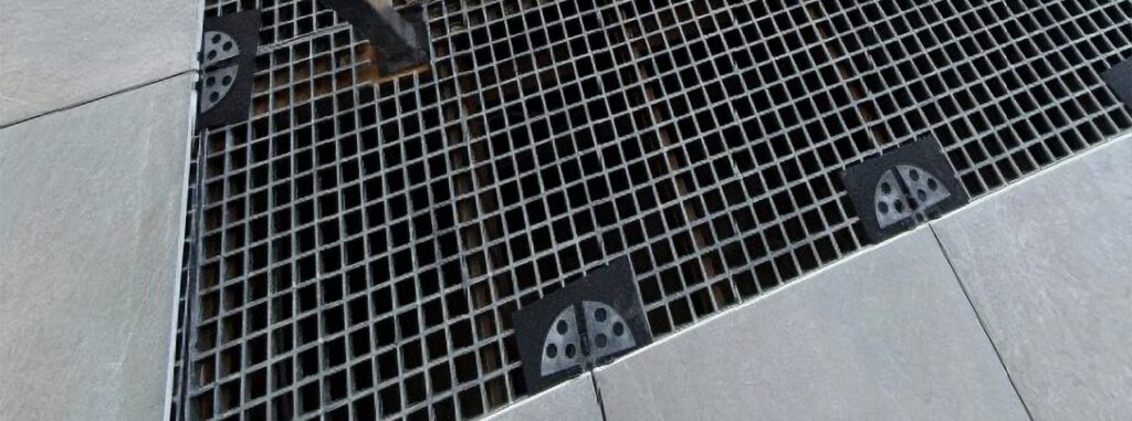 Elevated porcelain paver deck supported by HDG grating panels, Buzon U-Tabs Flat, and U-Pads Ground.
